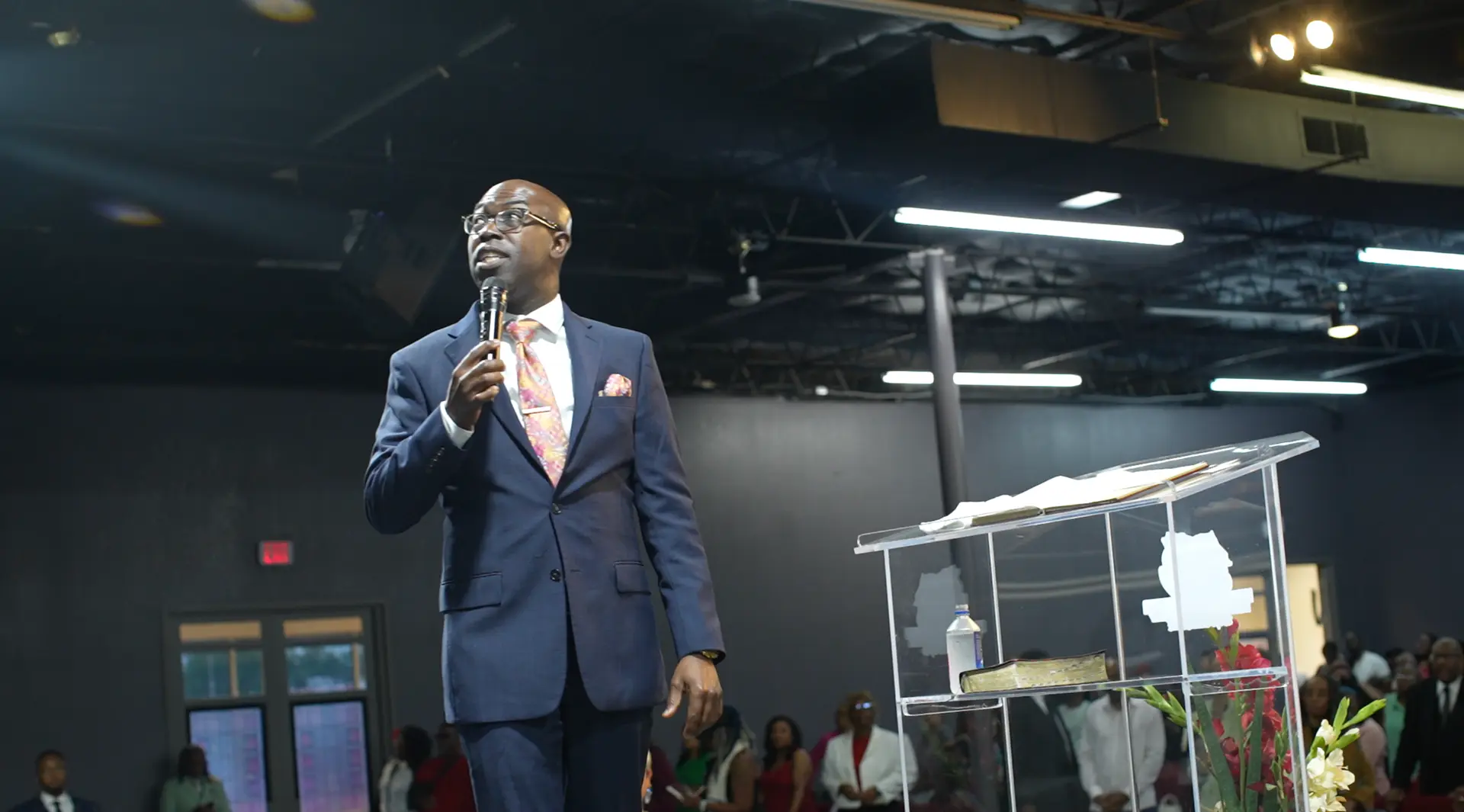 Apostle Frank Manu addressing the congregation during Sunday worship