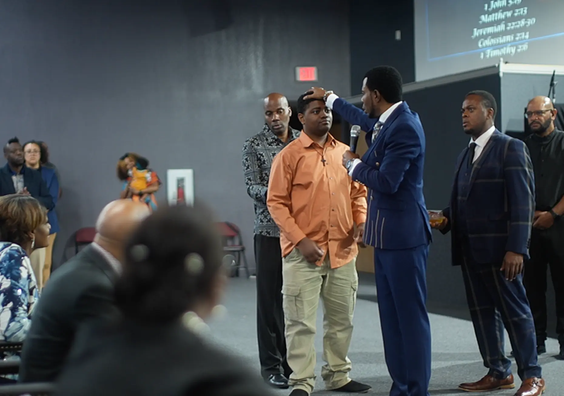 Apostle Frank Manu praying over a member during ministry time