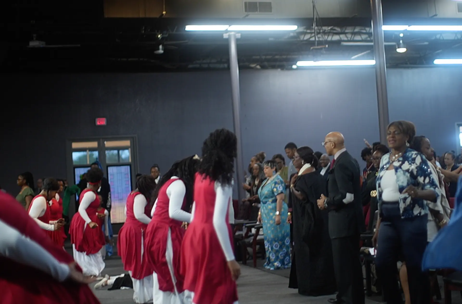 Praise dancers in red and white ministering in the aisle as the congregation worships