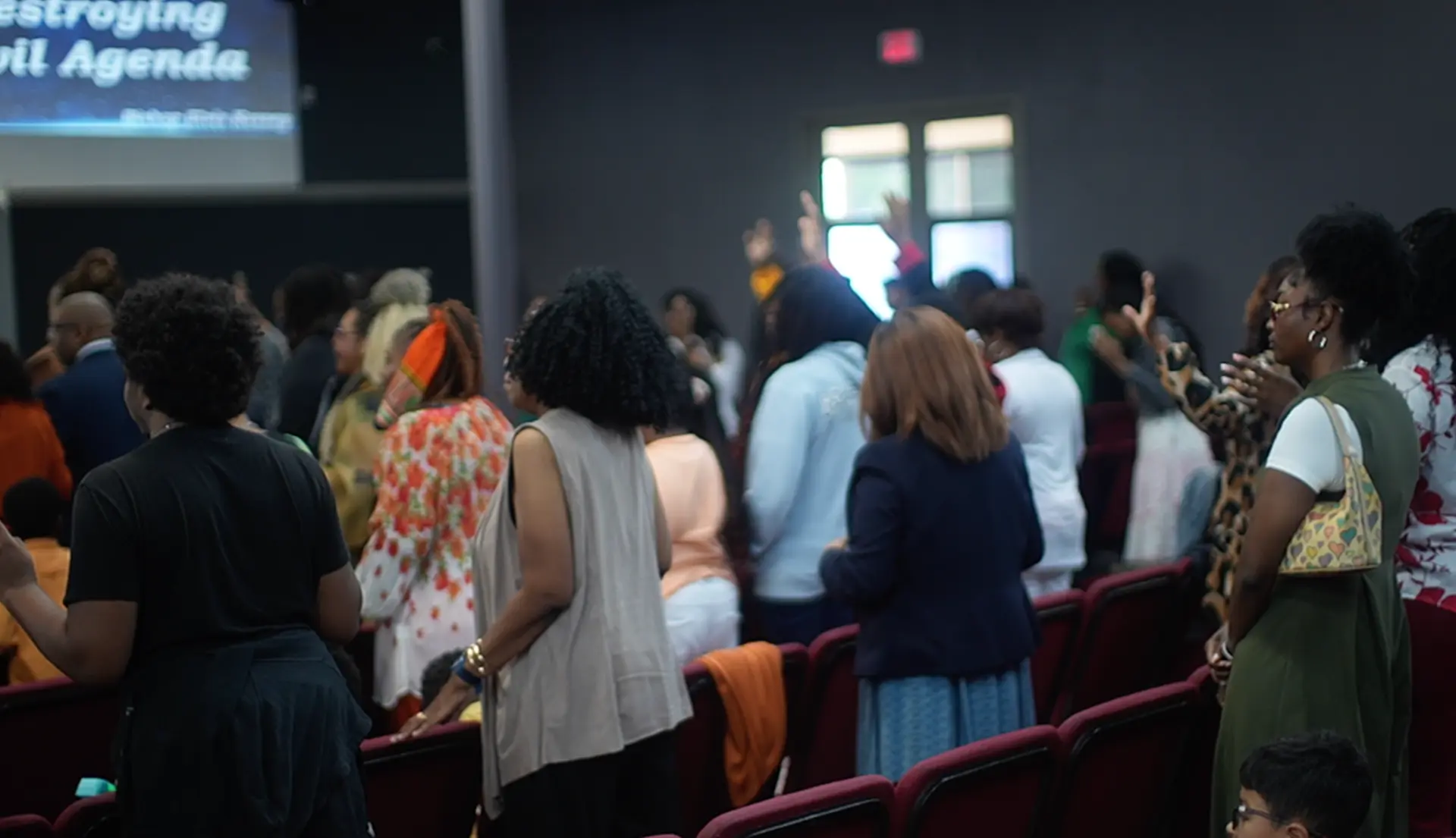 Congregation standing with hands raised in worship during service